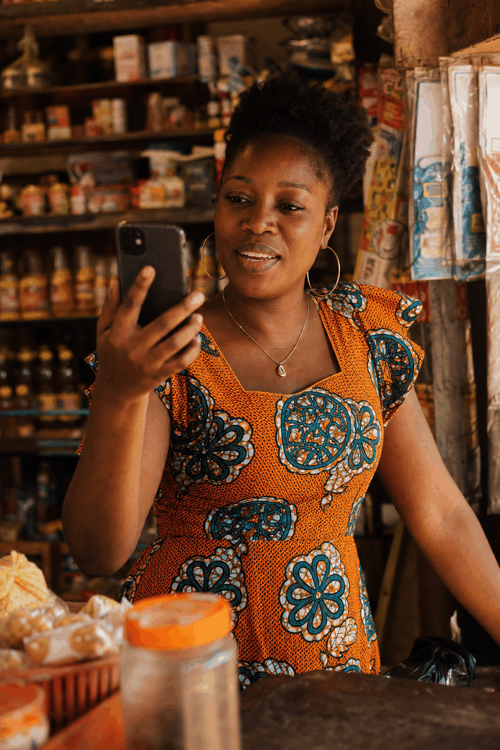 Une commerçante à Abidjan parle à Déblo sur son téléphone, dans sa boutique